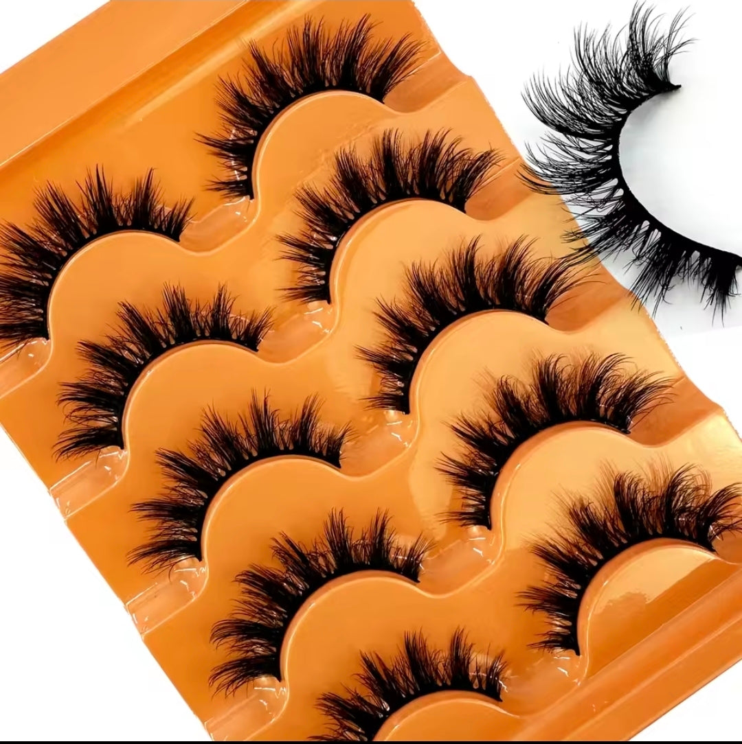Five pairs of black false eyelashes arranged in a wavy orange tray, with one pair shown separately on a white background in the upper right.