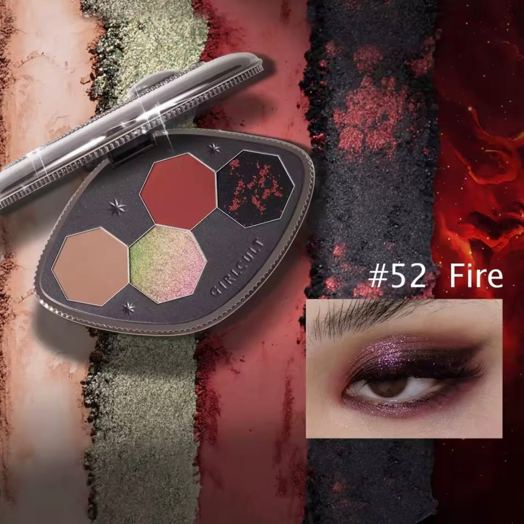 A makeup palette product shown open with three hexagonal pans in beige, muted red, and shimmering green, alongside a close-up eye makeup swatch labeled '#52 Fire' showing a purple shimmery look. The background is a textured multicolor design with red, black, and beige vertical bands.